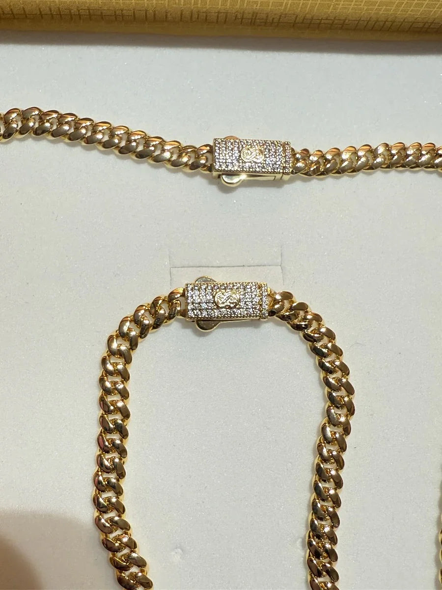 Conjunto de cadena y pulsera tipo cubana en oro con broche decorado con circonias brillantes