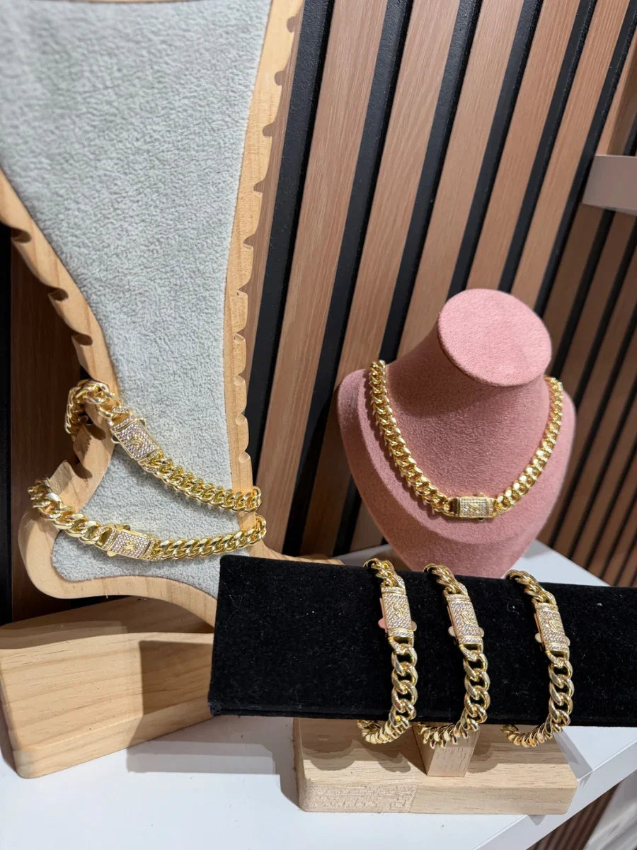 Conjunto de cadenas y pulseras de oro con eslabones gruesos y cierre brillante en exhibidor