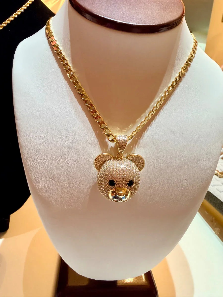 Collar de oro con dije de oso brillante, exhibido en busto de joyería
