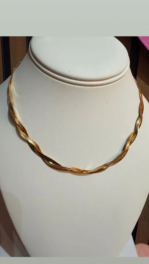 Collar de oro trenzado elegante para mujer, exhibido sobre busto blanco