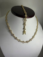Conjunto de collar y pulsera dorados con incrustaciones de circonias, diseño elegante.