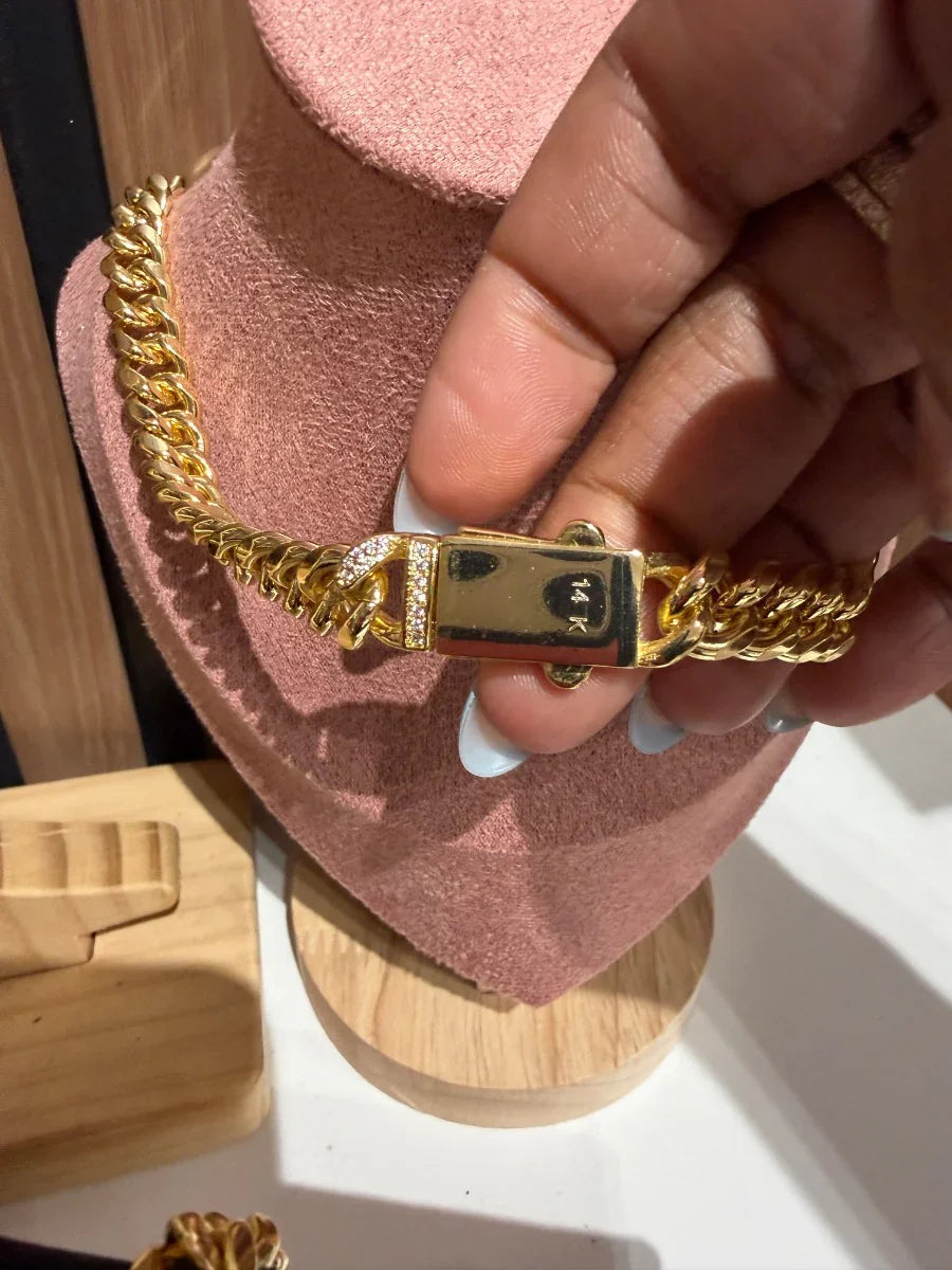 Pulsera de oro 14k con cierre decorado, exhibida en soporte para joyería