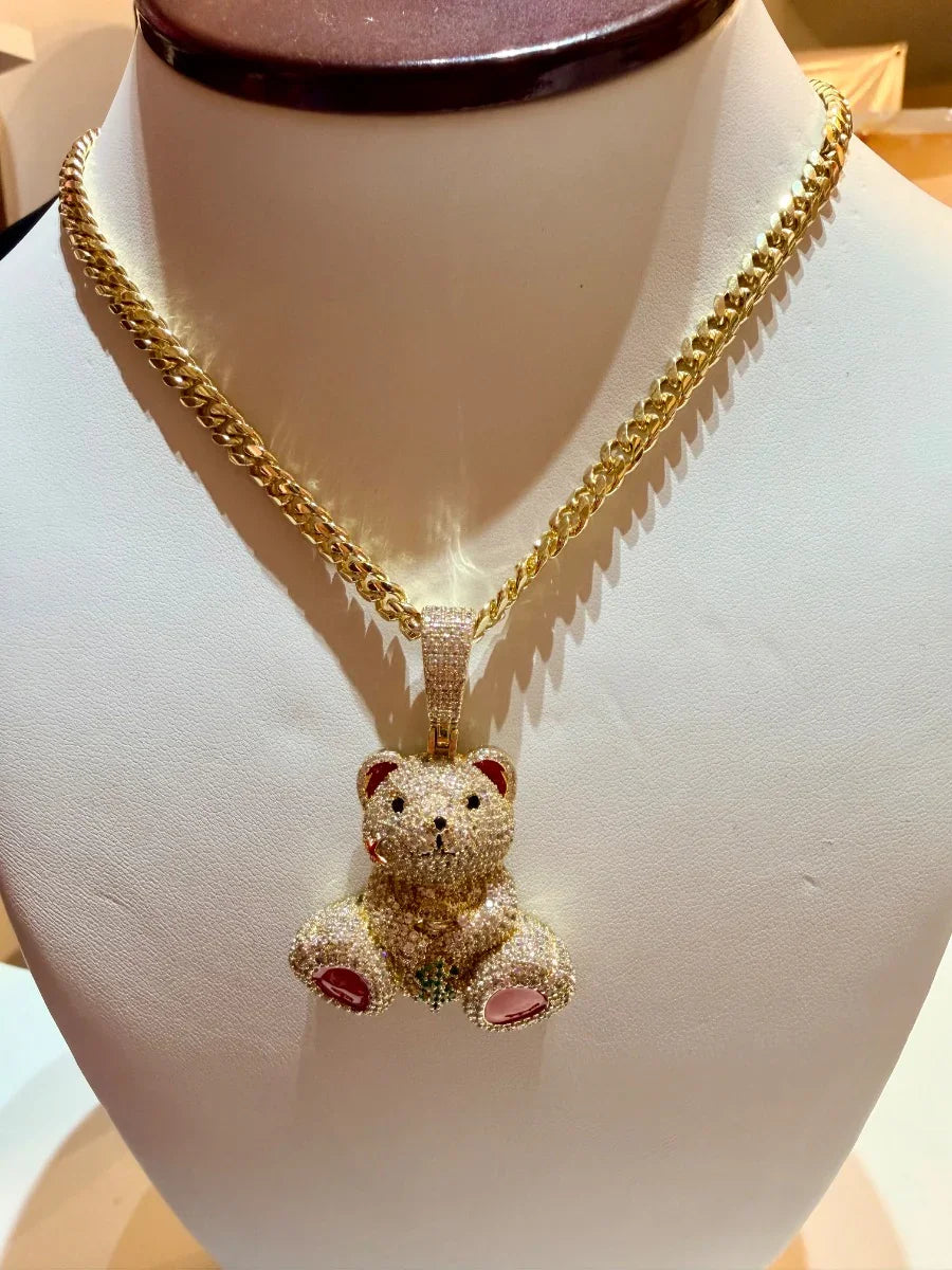 Collar de oro con dije de oso incrustado en diamantes, exhibido en busto de joyería.