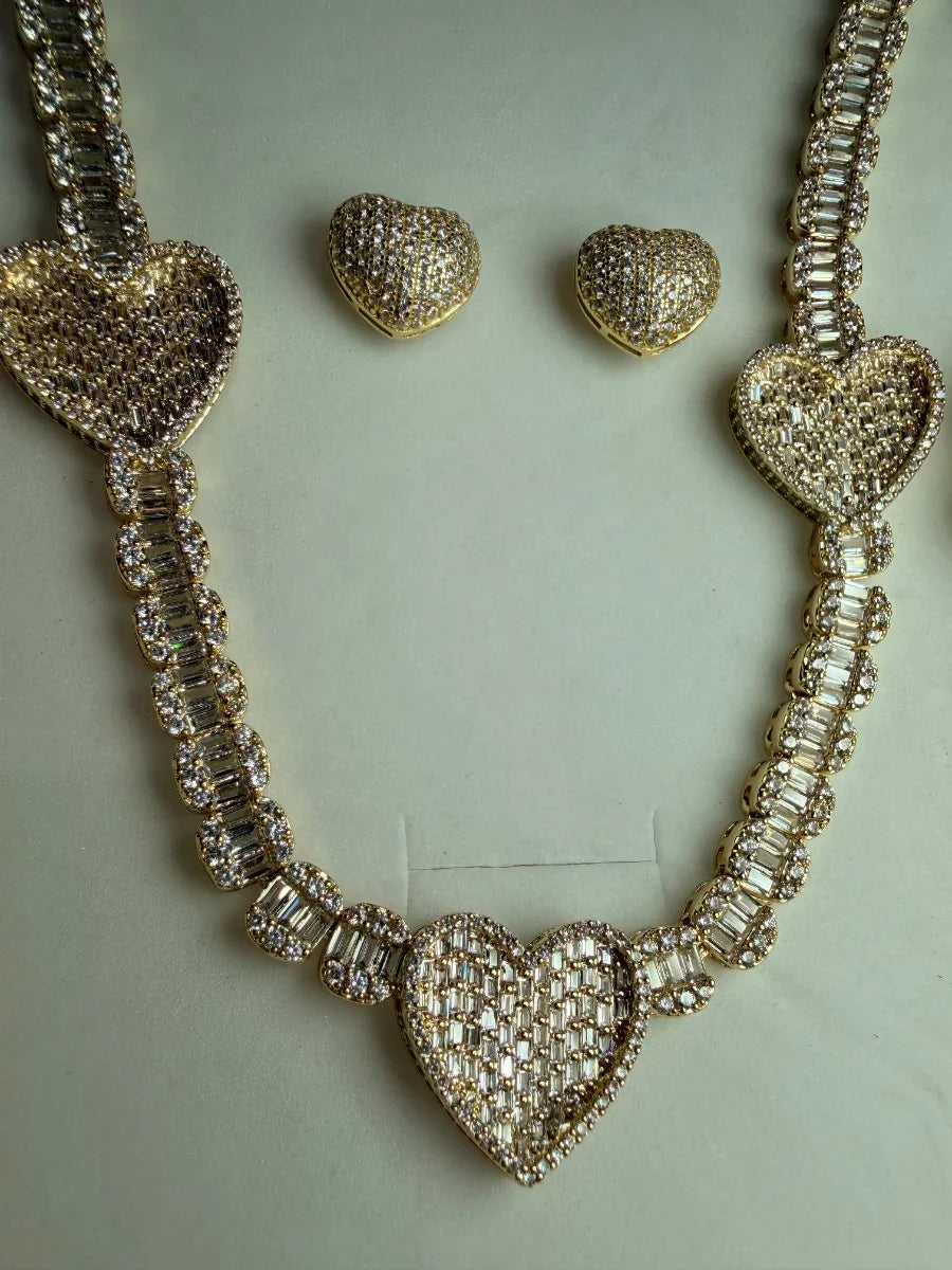Conjunto de collar y aretes dorados con incrustaciones de circonias en forma de corazón