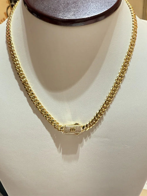 Cadena gruesa de oro para hombre con cierre de broche decorativo, exhibida en busto.